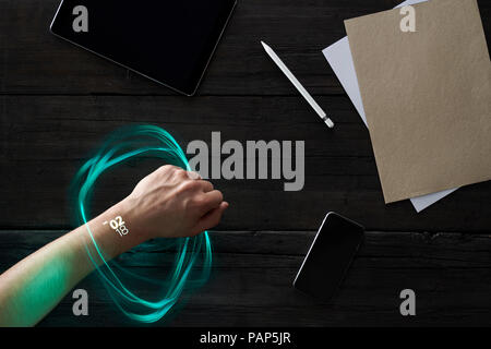 Il futuristico smartwatch sul polso il collegamento a dispositivi portatili Foto Stock
