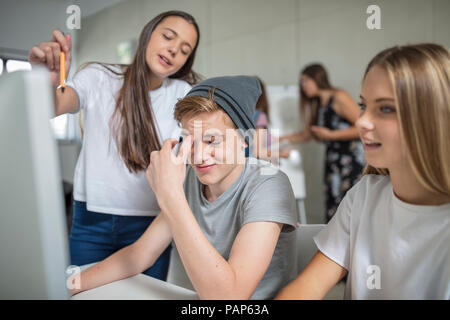 Gli studenti che lavorano su computer in classe insieme Foto Stock