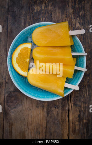 Fatta in Casa popsicles arancione nel recipiente Foto Stock