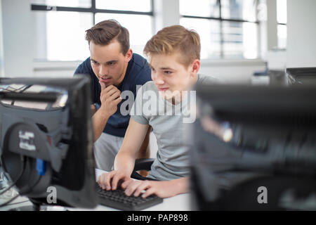 Insegnante e studente di usare il computer in classe Foto Stock