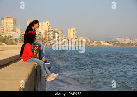 Due ragazze la vendita di rose rosse in Medio Oriente in Libano nella città di pneumatico nel porto di mare di denaro Lexpo di nutrire i loro fratelli Foto Stock