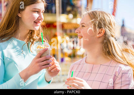 La Russia, Mosca, ragazze adolescenti bere un deliziosi frappé al luna park Foto Stock