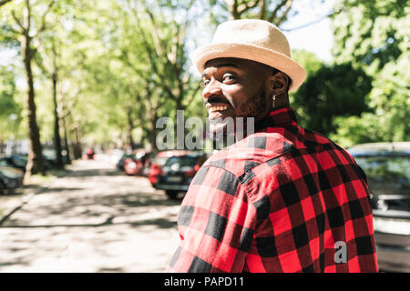 Giovane uomo a camminare in città, ritratto Foto Stock