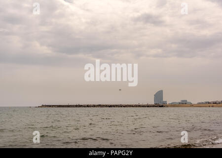 Silhouette skyline del Mare Mediterraneo vicino alla spiaggia di Barceloneta a Barcellona con frangiflutti, paracadute e a forma di vela grattacielo in background onu Foto Stock