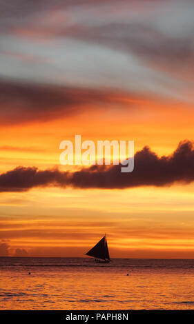 Barca a vela silhouette sotto un drammatico, nuvoloso isola arancione tramonto - Boracay, Aklan - Filippine Foto Stock