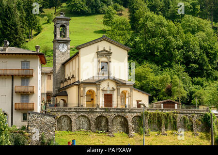 Facciata e campanile di Santa Maria Maddalena la chiesa, girato in condizioni di intensa luce estiva a Dezzo di Scalve, Bergamo, Orobie, Lombardia, Italia Foto Stock