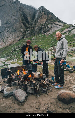 Norvegia Lofoten, Moskenesoy, giovani uomini iniziare un fuoco di campo a Bunes Beach Foto Stock