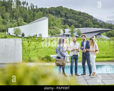 I colleghi sorridente in piedi fuori parlando Foto Stock