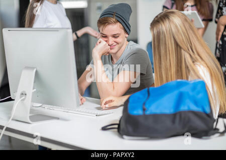 Gli studenti che lavorano su computer in classe insieme Foto Stock