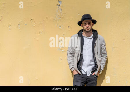 Uomo Barbuto che indossa black hat, pendente a parete Foto Stock