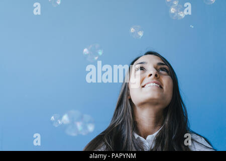 Piuttosto giovane donna che gioca con le bolle di sapone Foto Stock