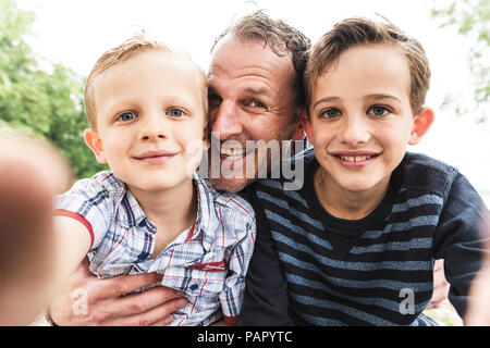 Selfie di padre felice con due figli all'aperto Foto Stock