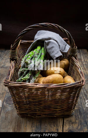 Verde biologico asparagi e patate organico in wiccurbasket Foto Stock