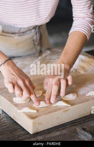 Donna preparare i ravioli sulla spianatoia Foto Stock