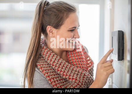 Sorridente giovane donna con citofono in office Foto Stock