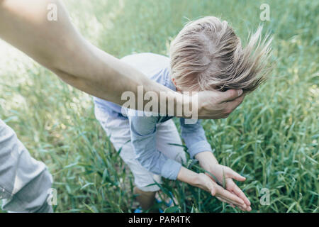 Uomo e ragazzo giocando in un campo Foto Stock