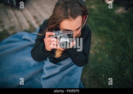 Giovane donna avvolta in una coltre di scattare una foto Foto Stock