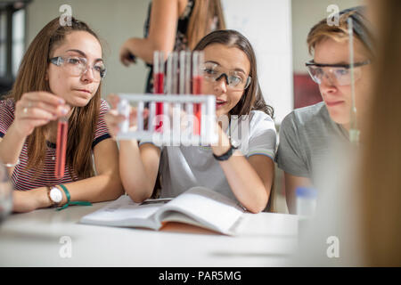 Gli studenti nella classe di scienze sperimentando con tubi di prova Foto Stock