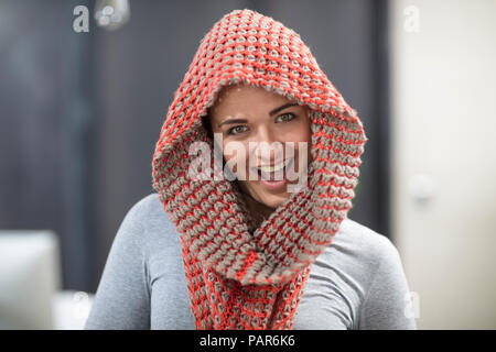 Ritratto di felice giovane donna che indossa una sciarpa in office Foto Stock