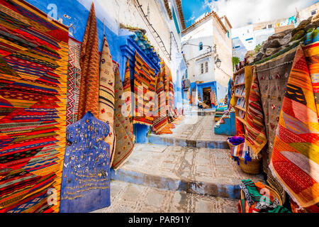 Vicolo stretto con tappeti e moquette, i concessionari Case blu, medina di Chefchaouen, Chaouen, Tangier-Tétouan, Marocco Foto Stock