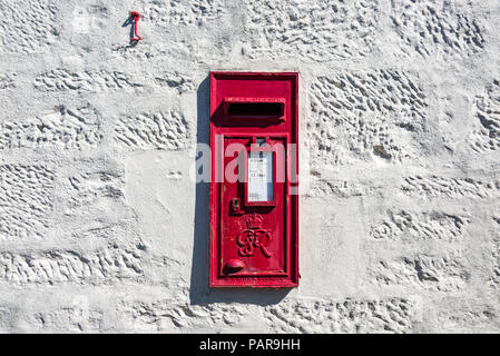 Una cassetta postale rossa posta in un muro di pietra bianco in Inghilterra, Regno Unito Foto Stock