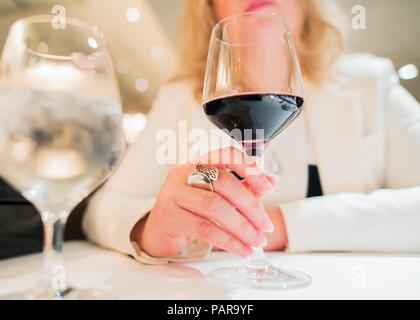 Donna con un bicchiere di vino presso il ristorante elegante. Primo piano. Foto Stock