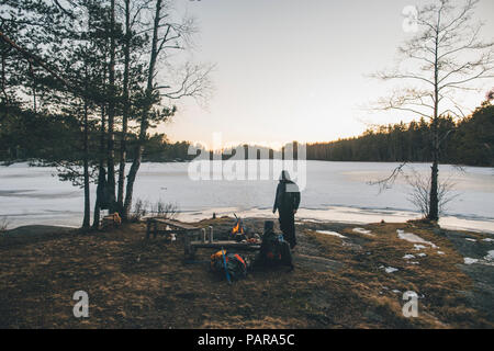 La Svezia Sodermanland, backpacker in appoggio in corrispondenza di un lago in remoto in inverno Foto Stock