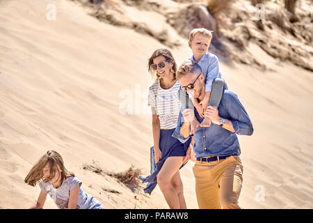La famiglia felice di camminare sulla spiaggia insieme Foto Stock