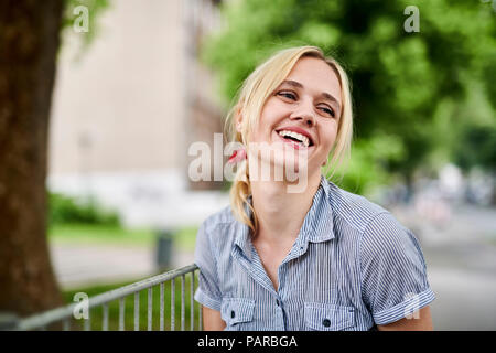 Ridere ragazza bionda in un recinto Foto Stock