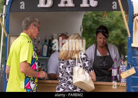 Coppia che acquista bevande da un bar mobile in un festival estivo in Hampshire, Regno Unito Foto Stock