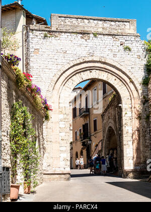 Un arco che conduce al centro della città nella città medievale di Assisi, in provincia di Perugia, Italia Foto Stock