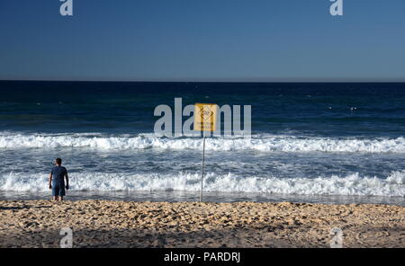 Sydney, Australia - Lug 5, 2018. Un segno legge corrente pericolosa. Nessuna bandiera piscina sulla spiaggia dopo la tempesta. Foto Stock