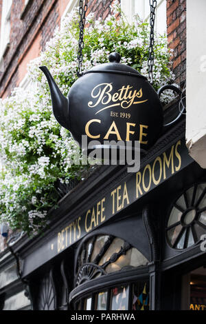 La facciata della Piccola Betty's Cafe e sale da tè a York Regno Unito mostra la grande teiera segno che pende dalla parte anteriore del negozio. Foto Stock