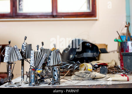 Le figure di esecutori di musica fatta con saldati con filo metallico, fisarmonicisti che suonano insieme in workshop, linee di vita. Foto Stock