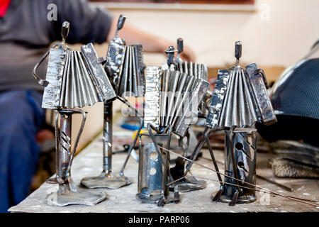 Le figure di esecutori di musica fatta con saldati con filo metallico, fisarmonicisti che suonano insieme in workshop, linee di vita. Foto Stock