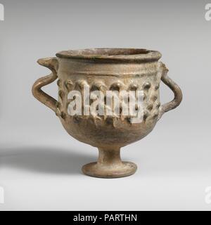 Piombo-vetrato tazza con gambo. Cultura: Romano. Dimensioni: H. 3 13/16 in. (9,7 cm); diametro 3 3/8 in. (8.6 cm). Data: 3° secolo D.C.. Questo footed, due-gestite cup è tipico della ceramica smaltata prodotti nella valle del Rodano in Gallia (moderna Francia) durante il successivo periodo imperiale. Museo: Metropolitan Museum of Art di New York, Stati Uniti d'America. Foto Stock