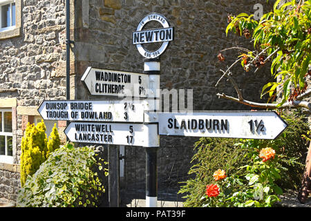 Vecchio stile signpost rurale nel villaggio di Newton nella foresta di Bowland Lancashire con segno quattro bracci post miglia di puntamento per tutte le direzioni England Regno Unito Foto Stock