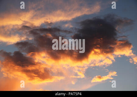 Bellissimo cielo rosso con le nuvole durante il tramonto. Sun insieme al Mar Baltico. La texture e sullo sfondo di un cielo blu d'estate. Foto Stock