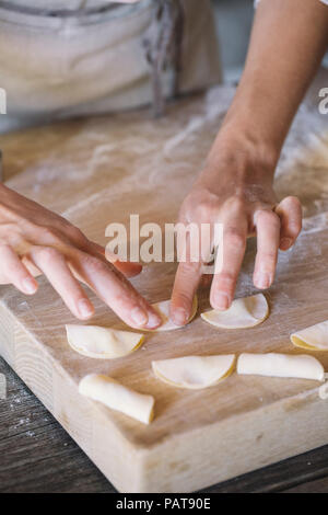 Donna preparare i ravioli sulla spianatoia Foto Stock