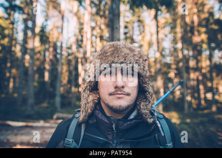 La Svezia Sodermanland, Ritratto di giovane uomo che indossa il cappuccio di pelliccia nel paesaggio remoto Foto Stock