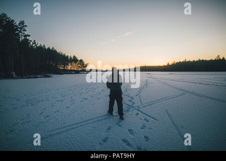 La Svezia Sodermanland, uomo a camminare sul lago ghiacciato Navsjon in inverno Foto Stock