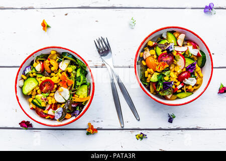 Due ciotole di insalata mista con fiori commestibili Foto Stock