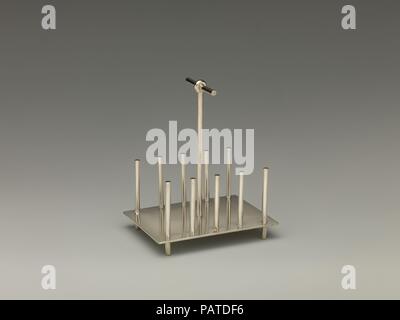 Toast rack. Cultura: British. Progettista: Christopher Dresser (British, Glasgow, Scozia 1834-1904 Mulhouse). Dimensioni: complessiva (conferma): 5 5/16 x 4 3/8 x 3 1/4 in. (13,5 × 11,1 × 8,3 cm). Produttore: Hukin & Heath (British, Birmingham, 1855-1953). Data: 1878. In un inizio di carriera nei primi 1850s e spanning cinquanta anni, cassettiera progettati beni compreso lo sfondo, vetro, tappeti, mobili di elementi in ferro battuto e le ceramiche per almeno cinquanta produttori. Molti dei suoi disegni possono abbastanza facilmente essere collocato nel contesto del orientalizing historicizing e il gusto del giorno, ma la sua lamiera Foto Stock