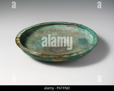 Patera in bronzo (shallow bowl). La cultura etrusca. Dimensioni: H. 2 3/4 in. (7 cm); diametro 14 a. (35,6 cm). Data: fine del IV secolo A.C. Piatto piano con un ampio labbro orizzontale. 'Suthina' in etrusco lettere è inscritto sulla patera. Museo: Metropolitan Museum of Art di New York, Stati Uniti d'America. Foto Stock