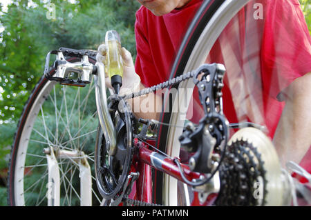 L'uomo è la riparazione della bicicletta. Manutenzione stagionale e la regolazione di un deragliatore di bicicletta. Foto Stock