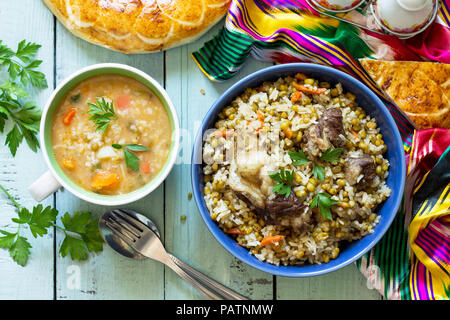 Cucina orientale. In casa la minestra di fagioli mung e riso con nucleasi di fagiolo e carni bovine. Vista superiore piatta sullo sfondo dei laici. Foto Stock