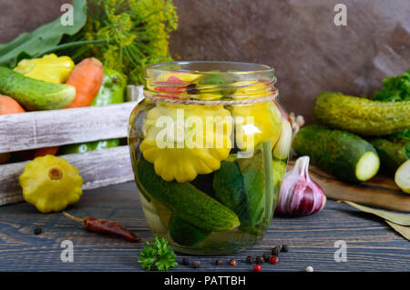 Verdure marinate in un vasetto di vetro. Un assortimento di cetrioli, peperoni, carote, patissons, zucchine. Pickles. Foto Stock