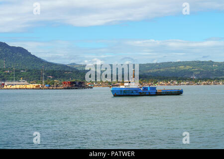 Blue galleggiante sul fiume barge contro la porta di carico Foto Stock