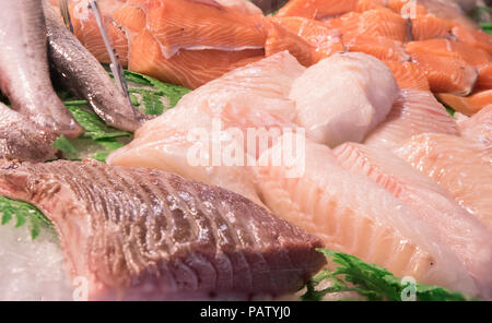 Un array di crudo fresco salmone e bianco i filetti di pesce sul ghiaccio in un nuovo mercato alimentare, Biarritz, Francia. Foto Stock