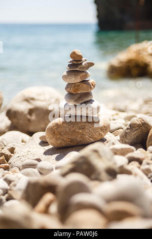 Torre in pietra fatta di ciottoli sulla spiaggia, animazione in spiaggia Foto Stock